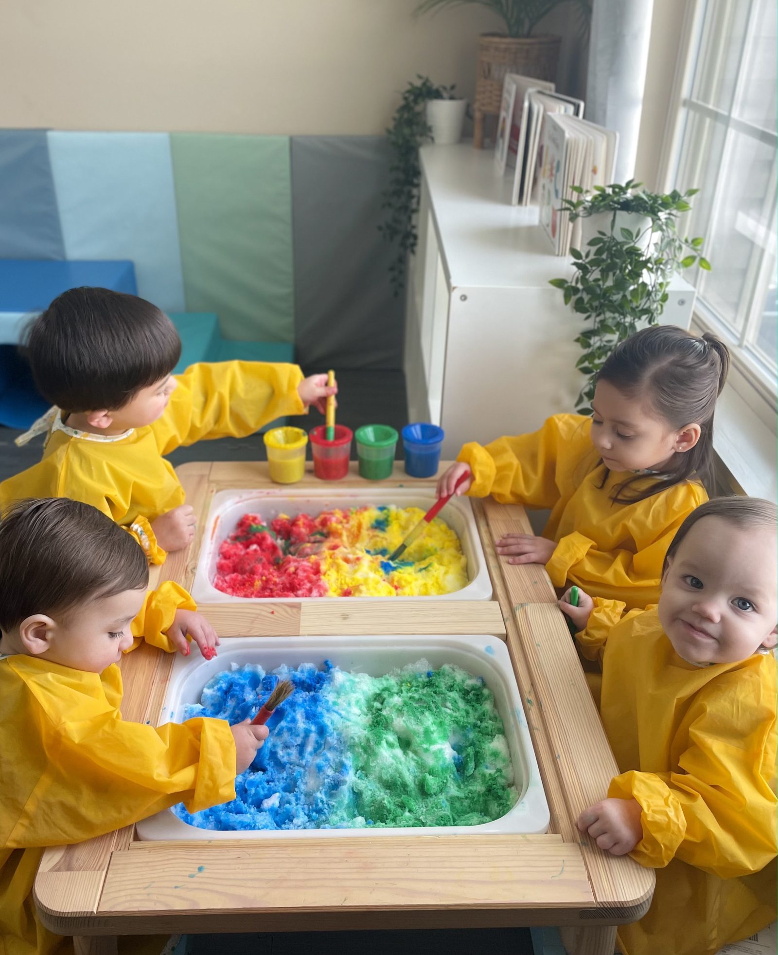 Painting colorful snow at the sensory table